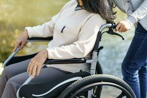 allaitement maison. Jeune soignant portion Sénior femme dans fauteuil roulant. photo