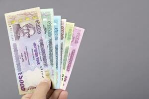 bangladeshi argent dans le main sur une gris Contexte photo