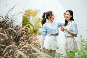 content asiatique femme et ami dans jardin. photo