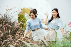 content asiatique femme et ami dans jardin. photo