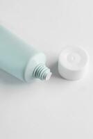 vert cosmétique tube pour visage ou corps crème, nettoyant ou shampooing sur une blanc Contexte. concept de minimalisme dans cosmétique emballage. copie espace photo