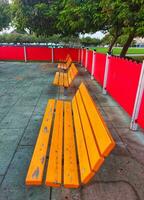 en bois parc banc ou séance chaise à Publique parc, en bois bancs sur une magnifique enfants aire de jeux.courbe Plastique banc ou siège dans jouer zone, chaises et les tables fabriqué de métal et bois photo