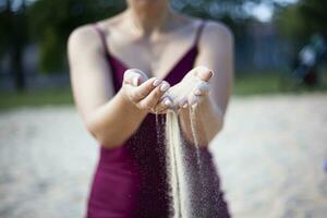 Jeune femme avec le sable dans mains photo