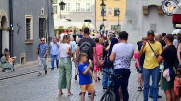 Varsovie, Pologne. 29 juillet 2023. foule de gens en marchant sur une rue. une foule en mouvement contre une Contexte de un Urbain vieux ville paysage. photo