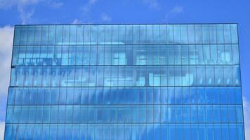 verre moderne bâtiment avec bleu ciel Contexte. vue et architecture détails. Urbain abstrait - les fenêtres de verre Bureau bâtiment dans lumière du soleil journée. photo