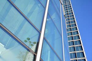 moderne Bureau bâtiment avec verre façade sur une clair ciel Contexte. transparent verre mur de Bureau bâtiment. photo