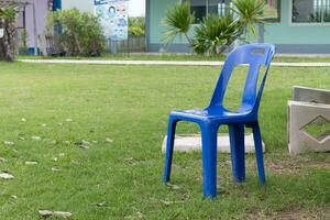 une bleu chaise est mis en plein air. sur le vert pelouse photo