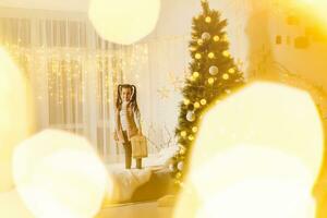 joyeux Noël et content vacances. peu fille dans le pièce décoré pour Noël photo