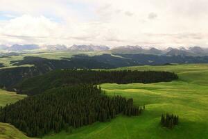 Montagne pics et prairie sont en dessous de blanc des nuages. photo