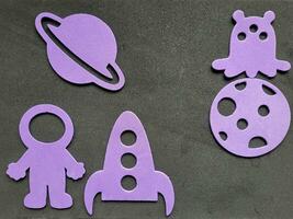 espace applique sur une noir Contexte lilas planète, fusée, astronaute, extraterrestre. photo