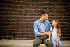 père et le sien fille avoir une bien temps dans de face de maison porte photo