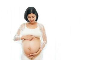 portrait de une Enceinte femme émouvant sa gros ventre proche en haut, mère, grossesse, gens et attente. femme en portant gros Enceinte estomac photo