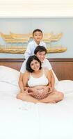 Jeune Enceinte femme et fils forme une chaud famille. photo