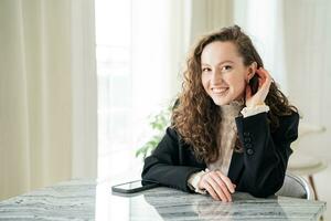 portrait de une affaires style femme dans un Bureau lieu de travail. une réussi directeur regards à le caméra et sourit. photo