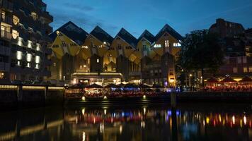 les maisons cubiques et les cafés au bord de l'eau dans la nuit de rotterdam photo