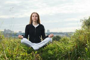 Jeune fille fait du yoga des exercices en plein air. photo