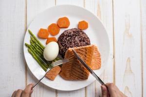 concept d'aliments santé, saumon avec riz et légumes sur fond de bois photo