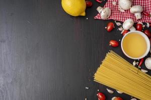 ingrédients spaghetti sur un bureau en bois noir, vue de dessus. photo