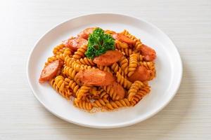 pâtes en spirale ou spirali avec sauce tomate et saucisses - style cuisine italienne photo