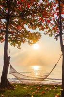 hamac près de la plage et de la mer à l'heure du lever du soleil