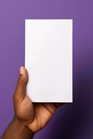 une Humain main en portant une Vide feuille de blanc papier ou carte isolé sur violet Contexte. ai généré photo
