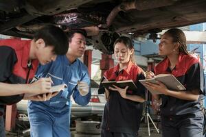 spécialiste conférence, Masculin superviseur ingénieur décris de l'essence automobile fixation avec mécanicien ouvrier Personnel équipes pour réparation travail à voiture un service garage et entretien emplois dans voiture industrie. photo