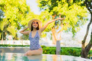 belles jeunes femmes asiatiques sourire heureux se détendre autour d'une piscine extérieure dans un complexe hôtelier pour voyager en vacances