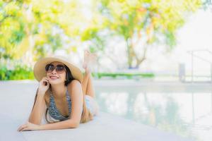 belles jeunes femmes asiatiques sourire heureux se détendre autour d'une piscine extérieure dans un complexe hôtelier pour voyager en vacances