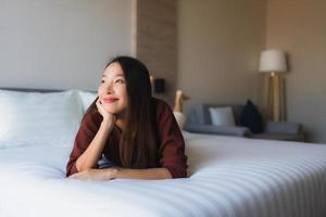 Portrait de belles jeunes femmes asiatiques sourire heureux se détendre sur le lit photo