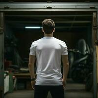 ai génératif une homme portant une plaine blanc t - chemise sur le garage orienté vers en arrière, parfait à créer T-shirt maquette photo