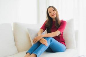 Portrait de belles jeunes femmes asiatiques sourire heureux s'asseoir sur le canapé