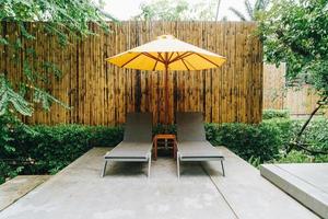 Parapluie et décoration de lit de piscine autour de la piscine de l'hôtel photo