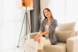 Portrait de belles jeunes femmes asiatiques sourire heureux se détendre assis sur une chaise canapé photo