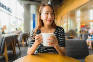 Portrait de belles jeunes femmes asiatiques dans un café et un restaurant avec un téléphone portable photo