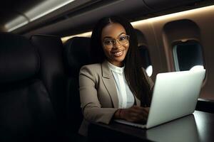 africain américain femme d'affaires avec portable sur avion assise dans affaires classe. génératif ai photo