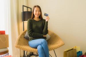 portrait de belles jeunes femmes asiatiques utilisant un ordinateur portable ou un téléphone intelligent et mobile avec carte de crédit pour les achats en ligne photo