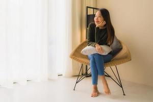 Portrait de belles jeunes femmes asiatiques sourire heureux se détendre assis sur une chaise canapé photo