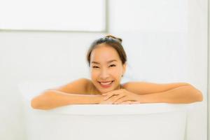 Portrait belle jeune femme asiatique prendre une baignoire dans la salle de bain photo