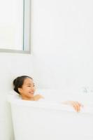 Portrait belle jeune femme asiatique prendre une baignoire dans la salle de bain photo