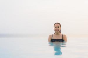 Portrait belle jeune femme asiatique sourire heureux se détendre autour de la piscine de l'hôtel resort