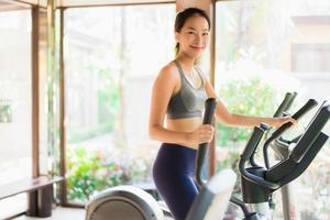 Portrait belle jeune femme asiatique exercice avec équipement de fitness à l'intérieur de la salle de sport photo