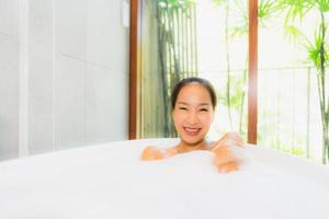 Portrait jeune belle femme asiatique prendre un bain dans la baignoire photo