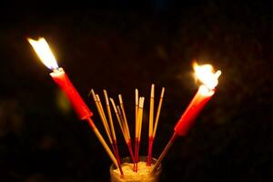 brûlant encens et rouge bougies à Payer hommage sur une foncé Contexte pendant faim fantôme Festival Payer hommage à leur décédé les ancêtres photo