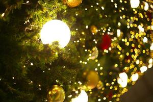 proche en haut décoration Balle et lumière ampoule sur Noël arbre à nuit photo