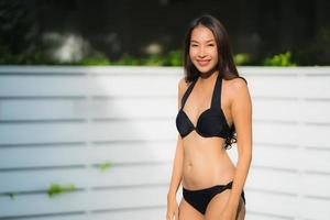 Portrait belle jeune femme asiatique sourire heureux se détendre autour de la piscine extérieure photo