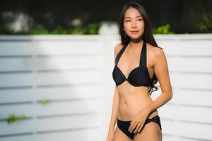 Portrait belle jeune femme asiatique sourire heureux se détendre autour de la piscine extérieure photo