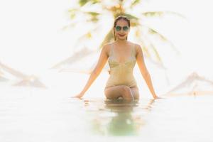 Portrait jeune belle femme asiatique sourire heureux et se détendre dans la piscine autour de l'hôtel resort photo