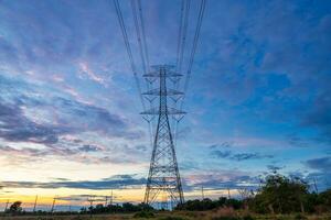 haute Tension Puissance transmission la tour, haute Tension pôle le coucher du soleil des nuages ciel arrière-plan, haute Tension la tour. photo