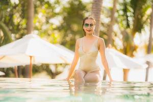 Portrait jeune belle femme asiatique sourire heureux et se détendre dans la piscine autour de l'hôtel resort photo