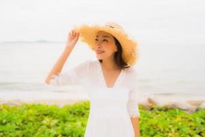 Portrait belle femme asiatique porter un chapeau avec sourire loisirs heureux sur la plage et la mer en vacances photo